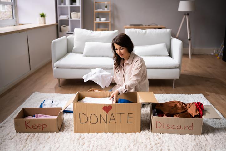 Woman Donating and practicing Decluttering tips And Cleaning Up Wardrobe Clothes