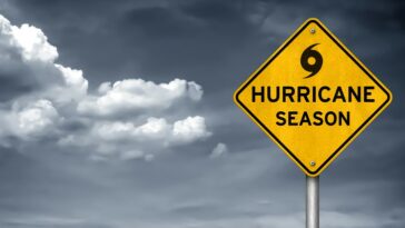 "Hurricane season" sign in front of cloudy skies.