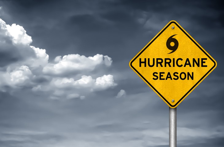 "Hurricane season" sign in front of cloudy skies.