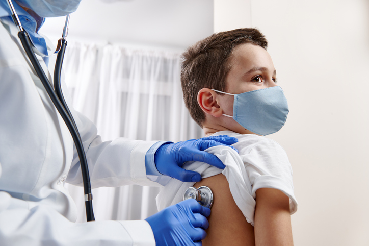 pediatrician using stethoscope to do a checkup on a child