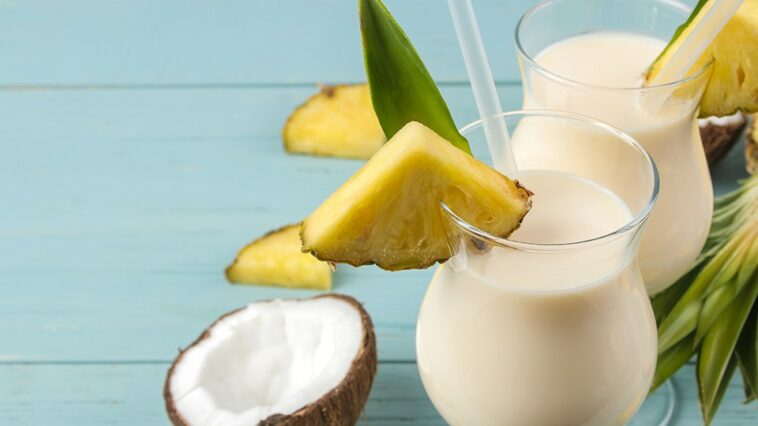 Frozen cocktail pina colada next to a coconut