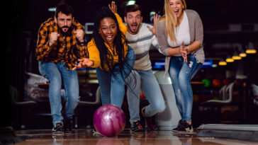 Four friends happily bowl together