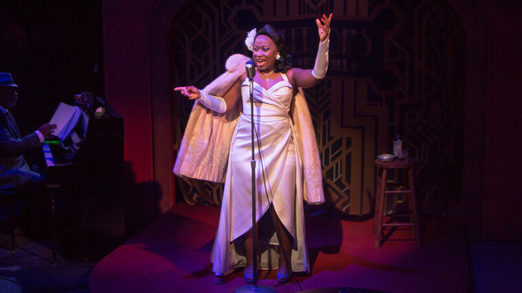 Woman stands at the mic singing a song.