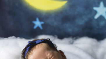 Newborn baby sleeps on clouds.