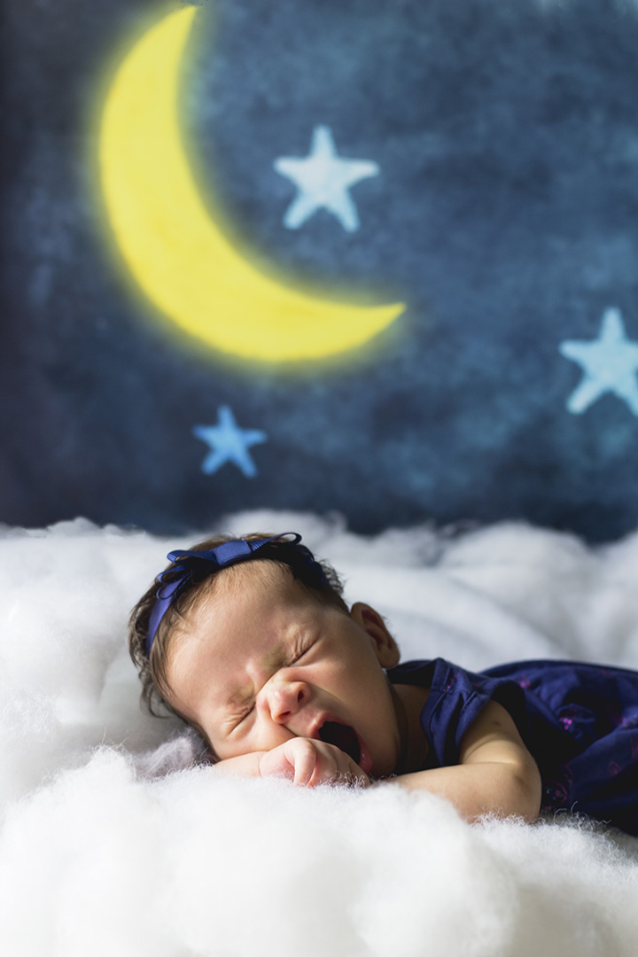 Newborn baby sleeps on clouds.