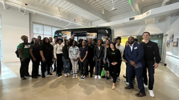 A group of people gather and smile for a photo