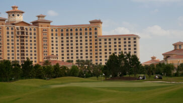 A hotel sits across a green lawn