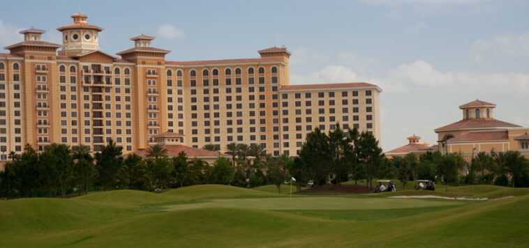 A hotel sits across a green lawn