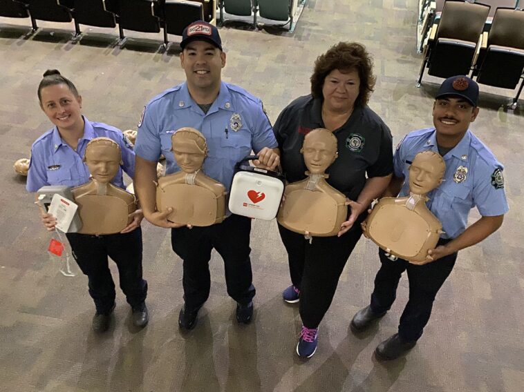 paramedics stand together with cpr dummies