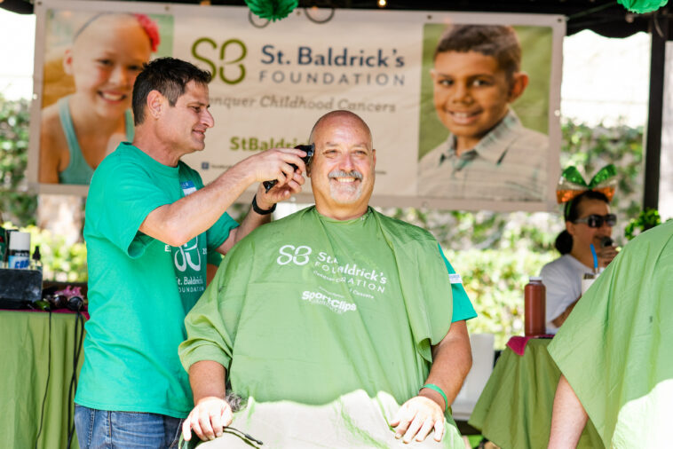 man getting head shaved at event for charities