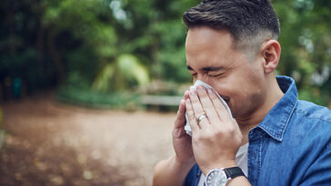 Man sneezing during allergy season.