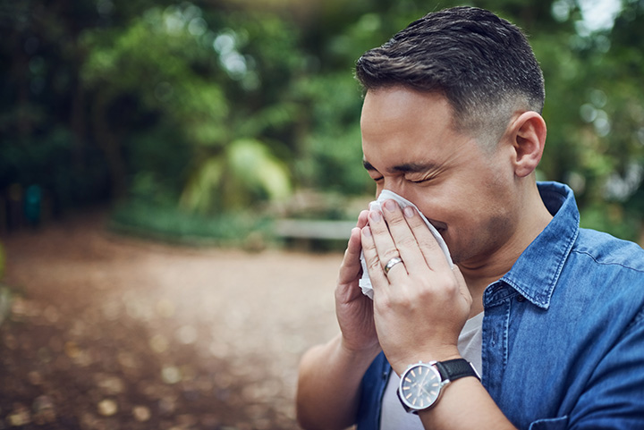 Man sneezing during allergy season.