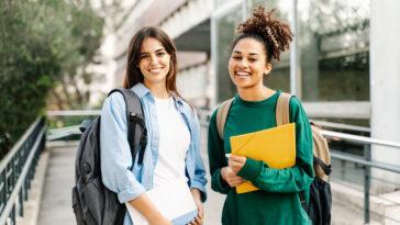 Two College Student female friends smiling ready for classes at the University campus