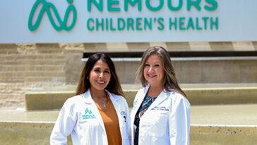 Photo of Dr. Taboada and Kubas, the maternal fetal medicine team standing in front of the Nemours Children's Hospital sign.