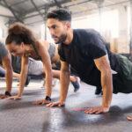 Fitness, gym with men and women doing plank, strong and exercise for muscle, cardio and endurance in workout class. Health, wellness and diversity, body training and healthy active challenge.