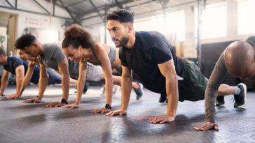 Fitness, gym with men and women doing plank, strong and exercise for muscle, cardio and endurance in workout class. Health, wellness and diversity, body training and healthy active challenge.