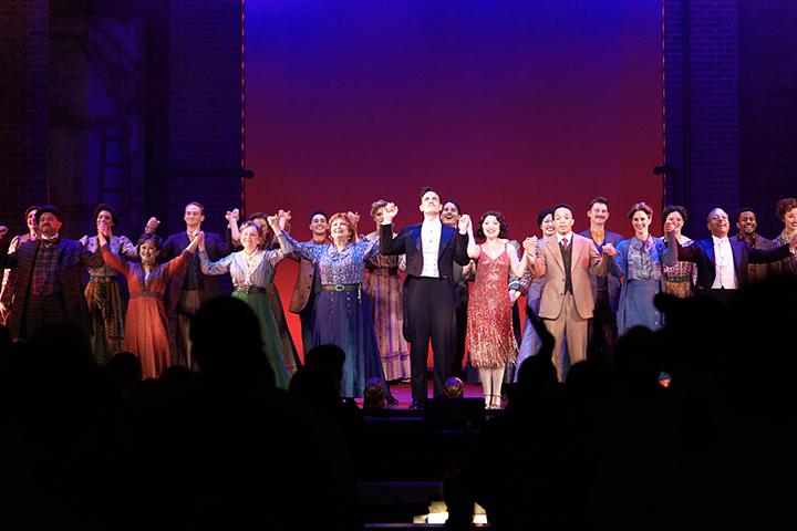 Cast members of Funny Girl join hands to bow as audience stands to applaud them at the end of the show.