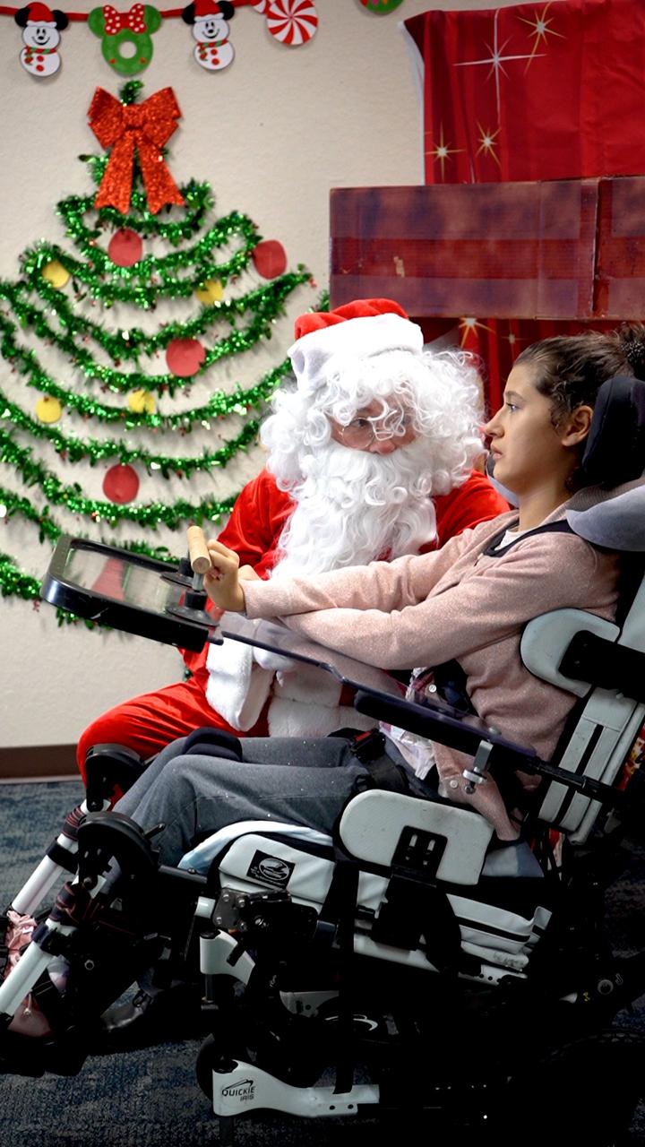 Photo of CECO student interacting with Santa at the school's annual family day event.