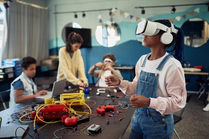 Portrait of young black girl using VR technology in engineering class representing STEM promotion at new East Campus of Orlando Science Charter School.