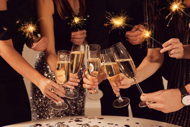 Friends clinking glasses of sparkling wine, closeup. New Year's Eve celebration