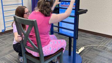 Photo of child with disabilities using the interactive ladder created by Full Sail University and CECO.