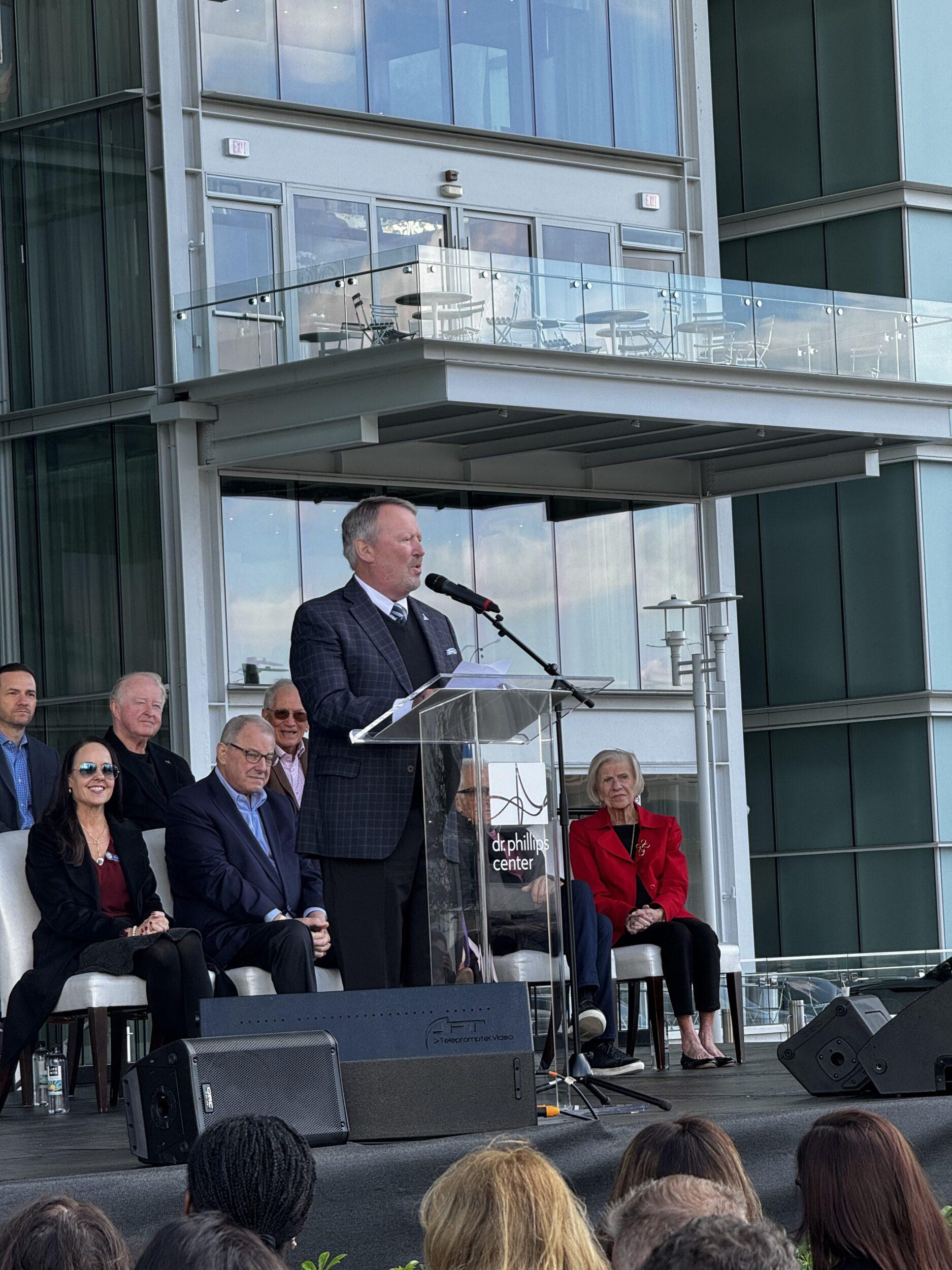 Mayor Buddy Byer of Orlando speaking in front of a crowd at Judson's Live ribbon cutting event.