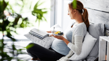 Young pregnant woman practicing yoga at home