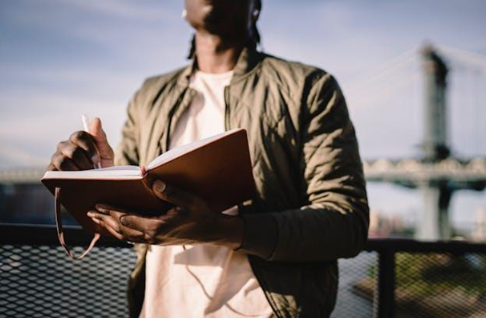 A man holding a notebook and a pen